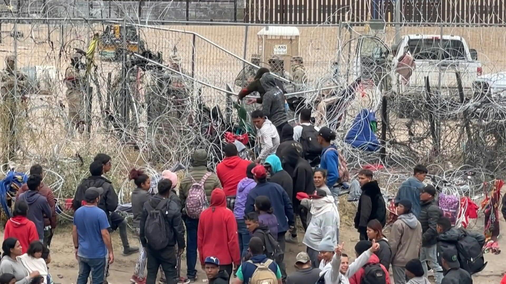 Migrants attempt to pull down section of wire fence on Mexico-US border
