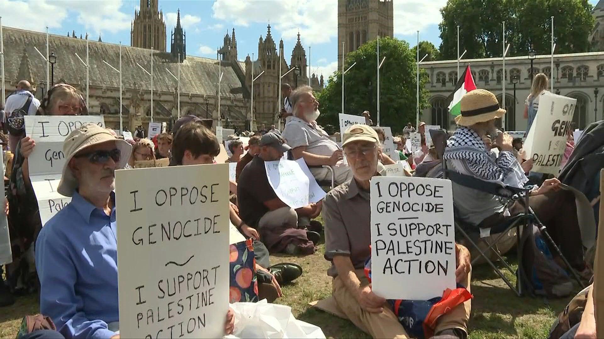 Demonstrators hold up placards in support of Palestine Action in central London