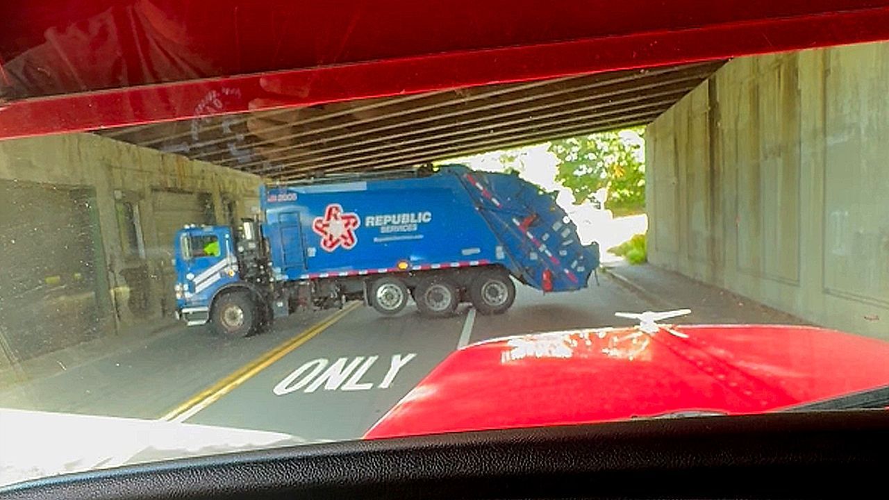 Garbage truck blocks traffic under bridge with '100-point' turn