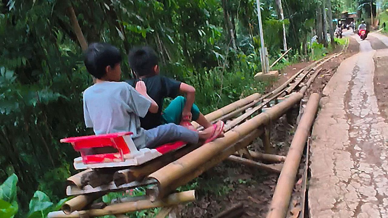 Kids ride homemade alpine coaster through Indonesian village