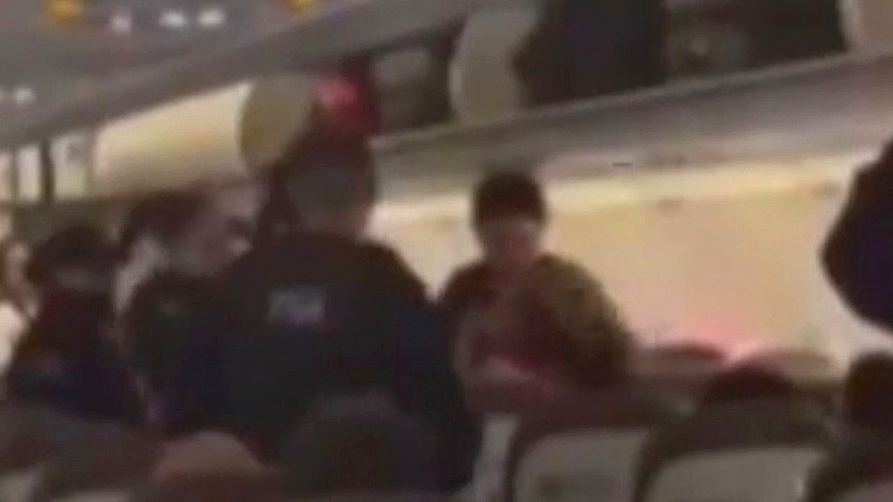 Video: Passenger bites police officer and refuses to leave plane over baggage dispute