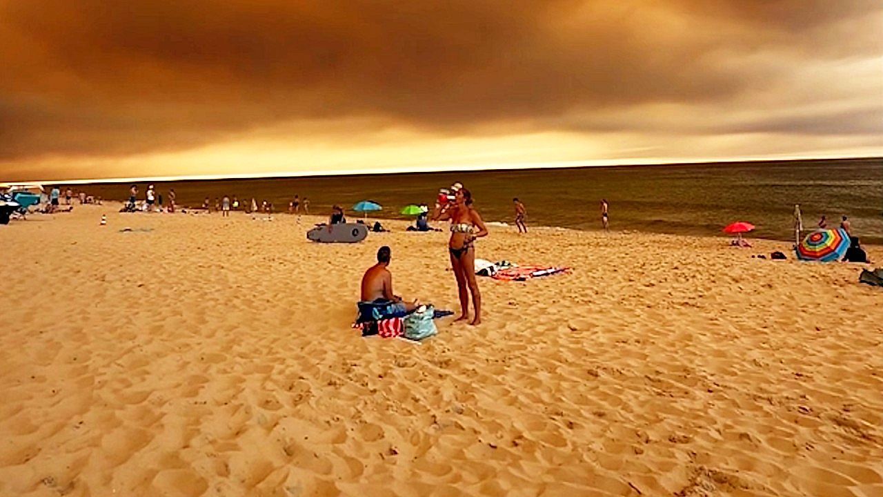 Video: Beachgoers remain on French Atlantic coast as wildfires and gloomy skies loom over
