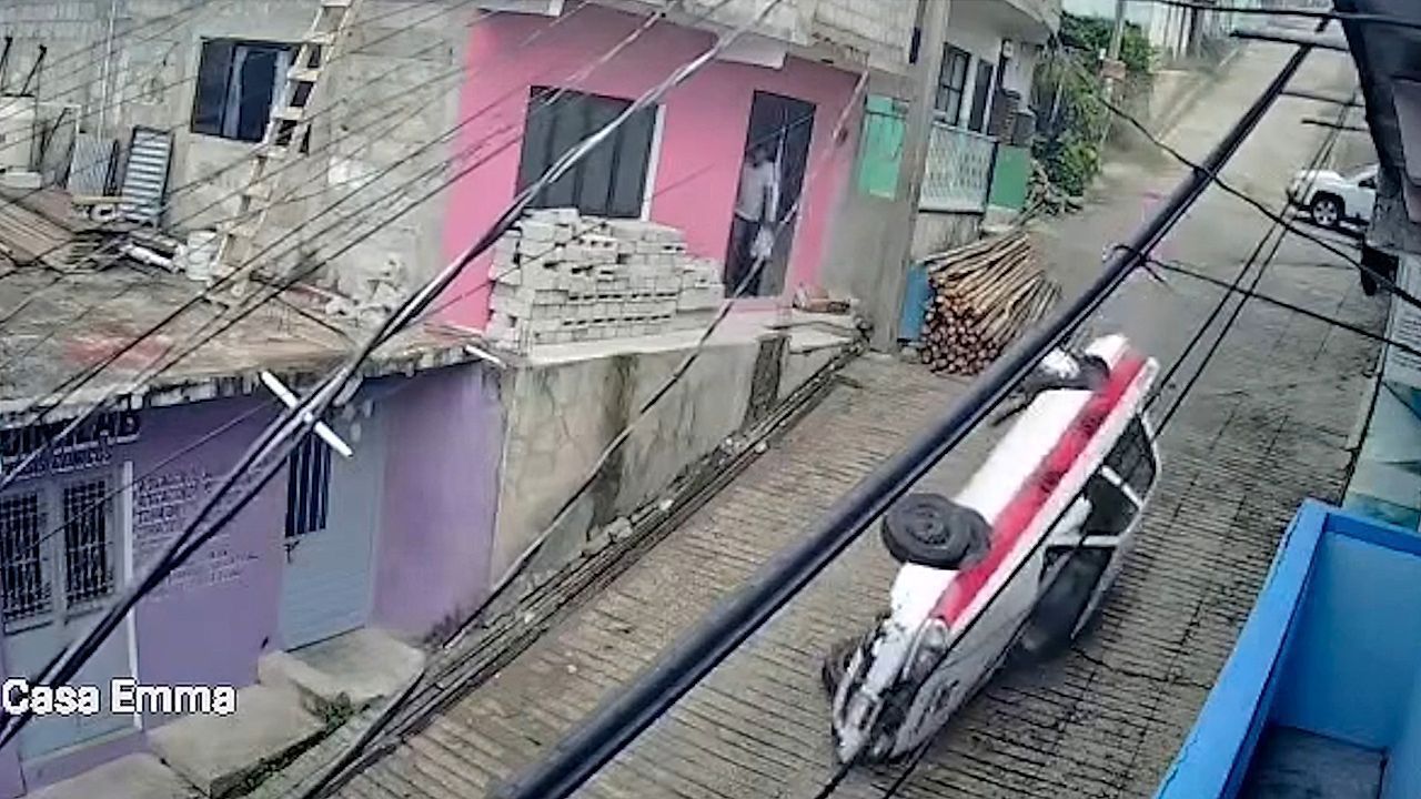 Video: Taxi overturns and slides down steep street leaving driver trapped